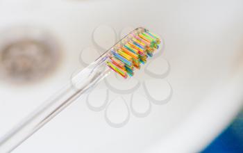 Colorful Toothbrush with Water Drops on White sink side view