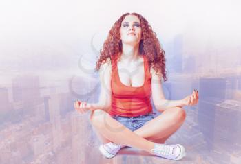 young woman do yoga meditation against blurred cityscape her eyes closed cross process toned