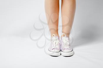 woman legs on white pink gumshoes on front view closeup
