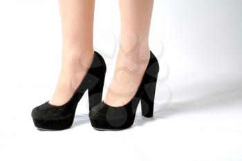 closeup picture of female legs and hot black shoes on white