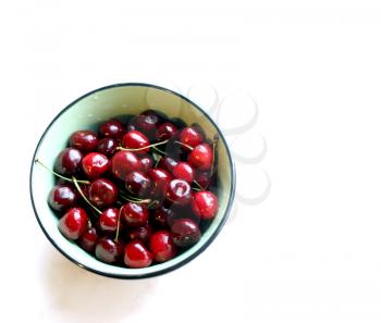 Bowl with ripe cherries on a white background. Vertical shot