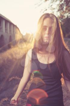 young blond women against gold sunset light. Autumn time. Backlit.Vertical shot with lens flares