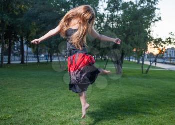 Long haired free style dancer. Girl jumping like flying bird.