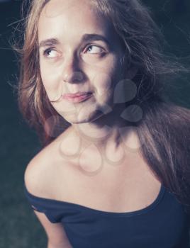 toned image of happy 20s young female outdoors in evening. Very close up shot.