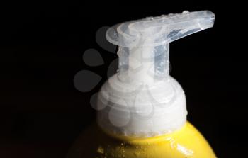 cap (head) of the yellow cosmetics spa bottle on black background