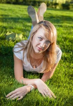 blond women laying on fresh grass in the day