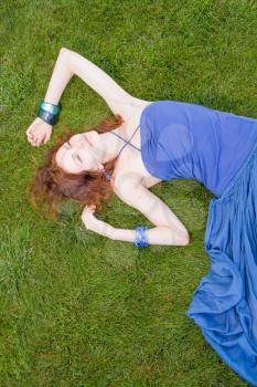 redhead women on grass daydreaming