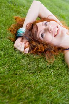 redhead smiling on grass, face closeup