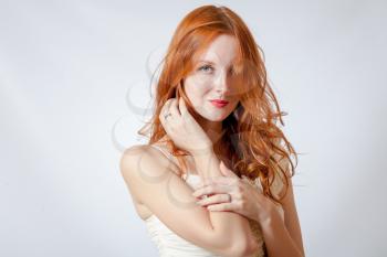 A beauty shot of a young blue eyed woman with her red hair