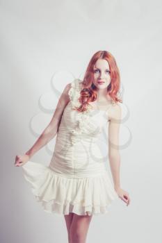 Fashion photo of young magnificent woman in white dress. Studio shot