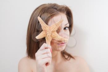 female face closeup, studio shot with seastar (starfish)