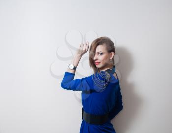 Portrait of a blonde woman with fashion hairstyle against light wall and a lot of copy-cpace