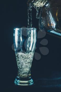 colorized image of shot glass and pouring drink on black