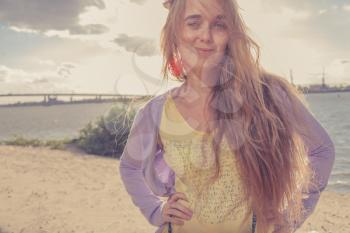 Girl smiling. Beautiful girl in the morning on the beach. Colorized shot. Retro looking image.