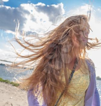 Wind in hair. Beautiful girl in the morning on the beach.