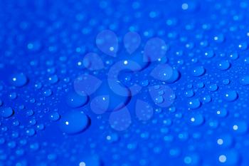 Angle view of the water drops on blue background