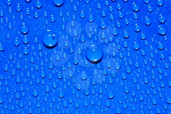 Rainbow drops on surface. Water drops on blue background