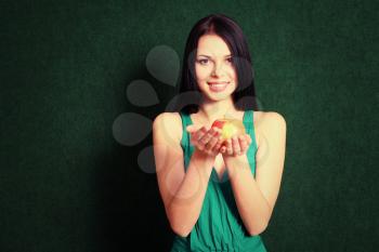 Smiling girl. Front view of the 20s female holding an apple in her hands