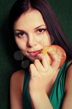 women with apple near face smiling. Women playing with apple