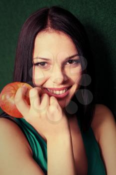 women with apple near face smiling
