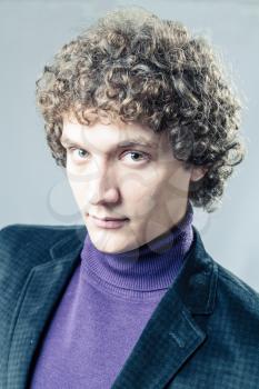 Very serious man. Detailed portrait of a young caucasian guy with curly hair