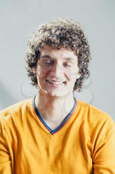 Closed eyes portrait of a young caucasian guy with curly hair