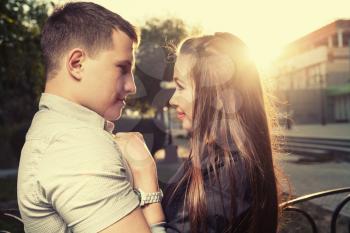 Backlit image of cute couple embracing outdoors