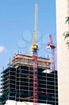 Building cranes against clear blue sky