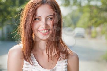 Happy teen redhead women smiling outdoors closeup image.