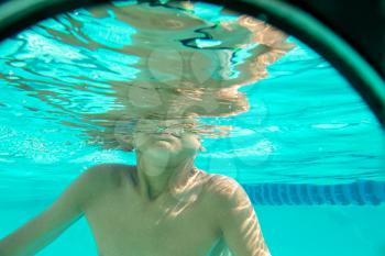 Boy half in water underwater photo in transparent water