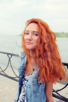Image of a red haired women in happy state outdoors. Summertime fun