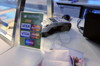 ASTRAKHAN, RUSSIA - JULY 11, 2014: Local store POS-terminal and banner with logo of Visa, Mastercard and PRO100 - Russian national alternative payment system developed by SBERBANK (lagest national ban