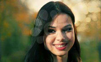 Headshot of a beautiful young woman outdoors smiling