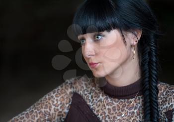 Head and shoulders side view shot of black haired women  on a dark background