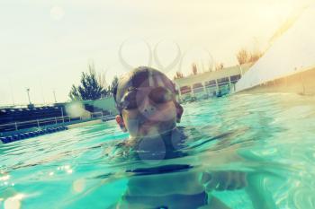Boy in swimming pool half in water instagram style image