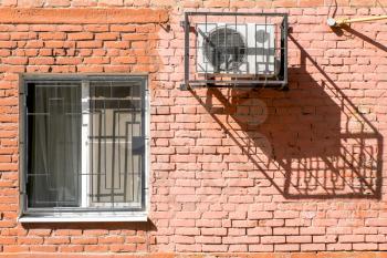 Window and air conditioner on a brick wall.