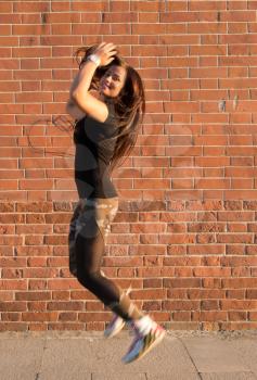 Brunette jump near wall, street dancer performing