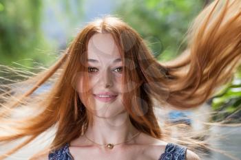 Red hair flying by wind. Summer fun and joy. Blurred motion shot