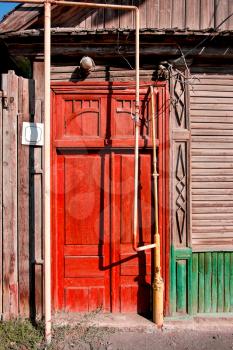 Bright red door of the slum house in Astrakhan, Russia