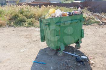 Green trash dumpster in ghetto outdoors