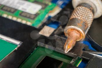 Rusty screwdriver is lying on computer motherboard