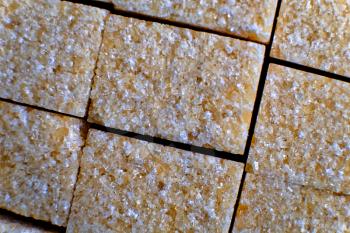 Brown sugar cibes in rows macro image in pack top view/ We can see mi of white and brown crystals