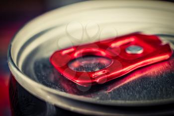 Macro photografy of lid of metal can of fizzy drink with bright red ring-opener