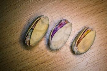 Three Pistachios over the wooden background of tabletop