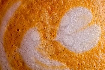 Macro of froth art on coffee top with heart shape on brown