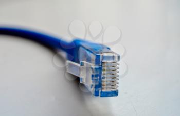 Macro cross section front angle view of blue RJ45 CAT6 shielded network data internet cable connector on gray background with copyspace.