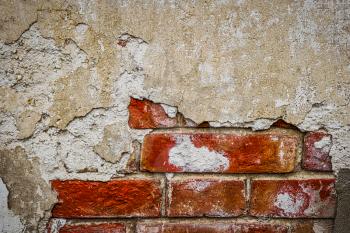 Damaged wall with weathered plaster and old red brickjs. Copyspace. Home renovation or repair works concept.