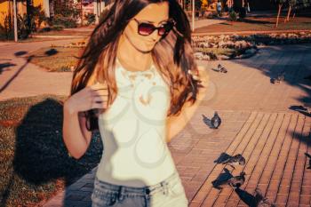 Young woman walking outside on alley with doves, blurred female, unusual shot. Copyspace.