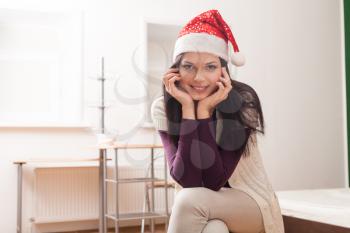 brunette weared santa hat smiling indoor