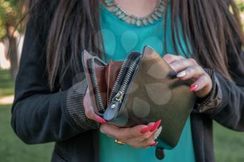Girl looking into small fashion handbag.